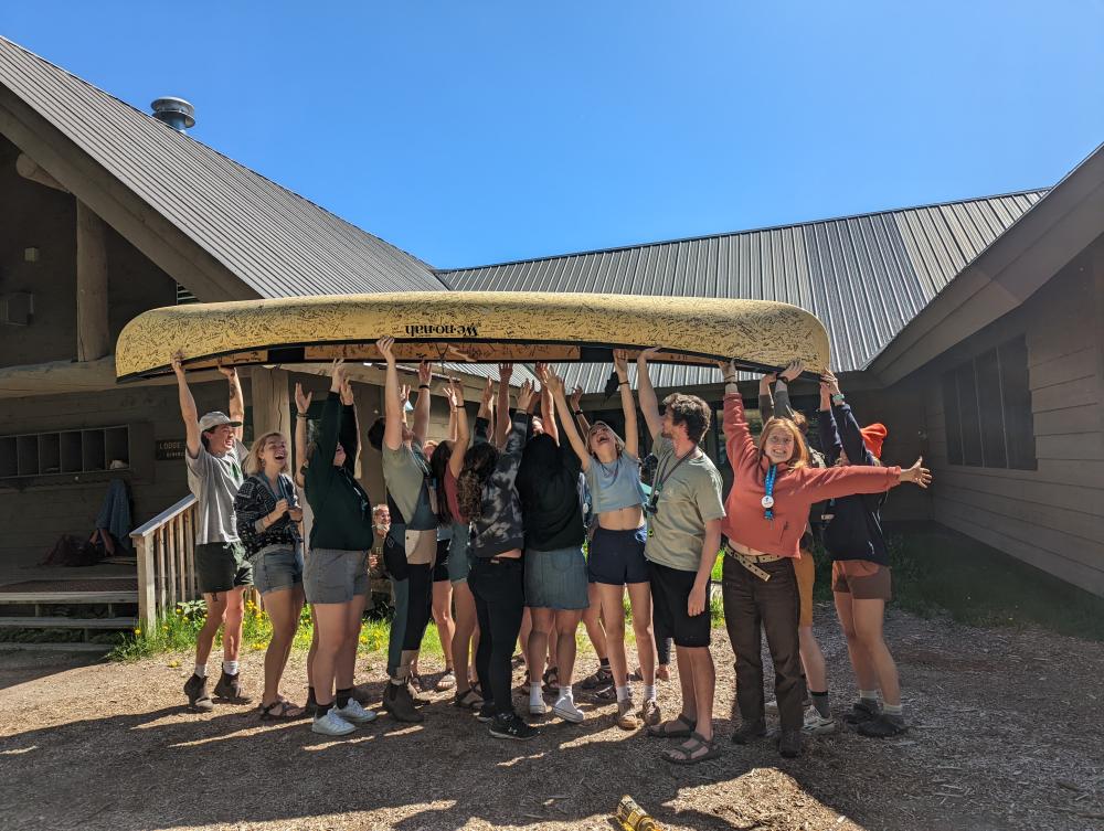 Youth holding up a canoe at summer camp