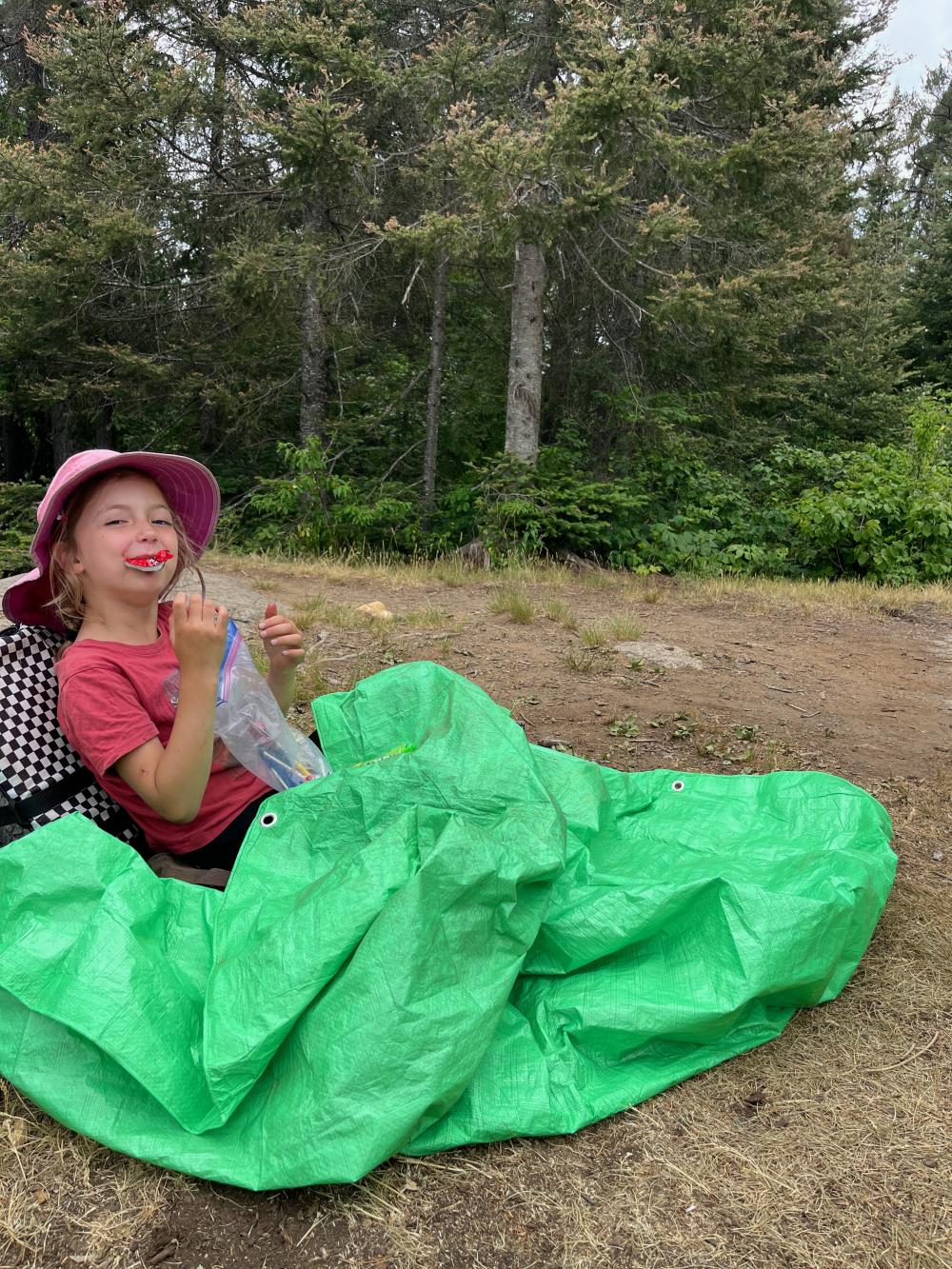 Kid enjoying candy with a green blanket