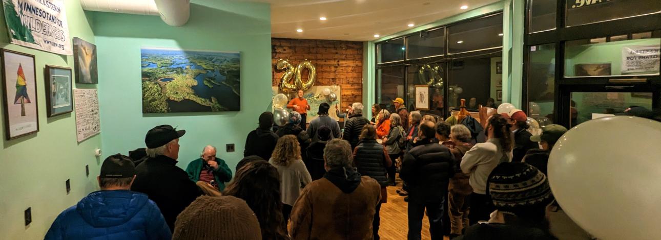 A group of people listen to the Executive Director give a speech.